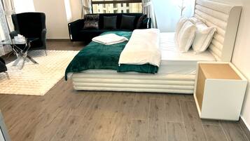 A modern bedroom with a bed, a chair, and a small table.