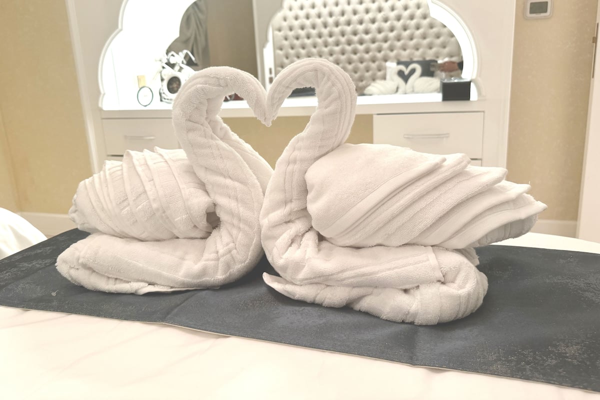 Une salle de bain avec un miroir, une tête de lit capitonnée et un lavabo.