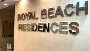 Una pared con el texto "ROYAL BEACH RESIDENCES" en letras metálicas.