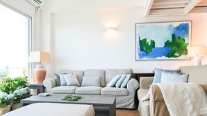 Una sala de estar con un sofá color beige, una mesita de centro y un cuadro en la pared.