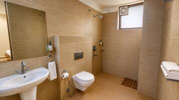 Un baño moderno con lavamanos, inodoro y ducha.