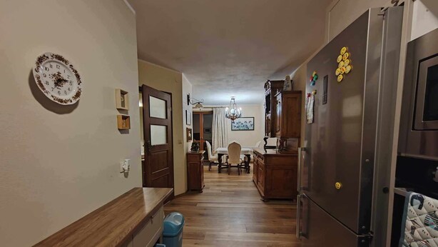 A hallway with a wooden floor, a dining area with a chandelier, and a kitchen with a refrigerator and cabinets. - 1bed Apartment - Sleeps 4 - Terrace, Pets, Parking (gmina Krasne)