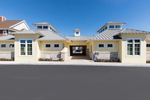 A modern building with a central entrance, stone accents, and a clear sky. - 4 BR 4 BA Villa 5min Disney Family Getaway (Kissimmee)