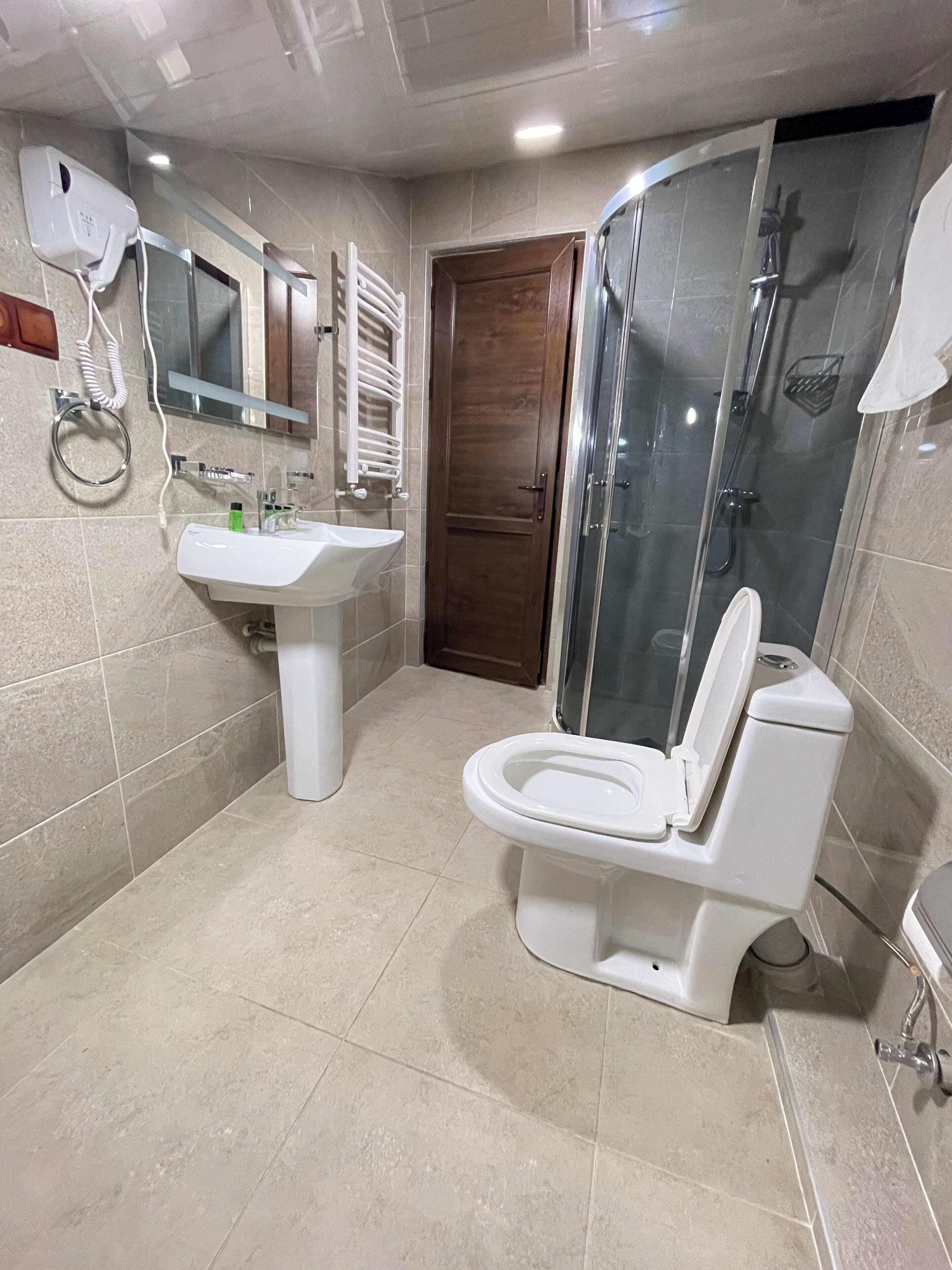 A modern bathroom with a toilet, sink, and shower.