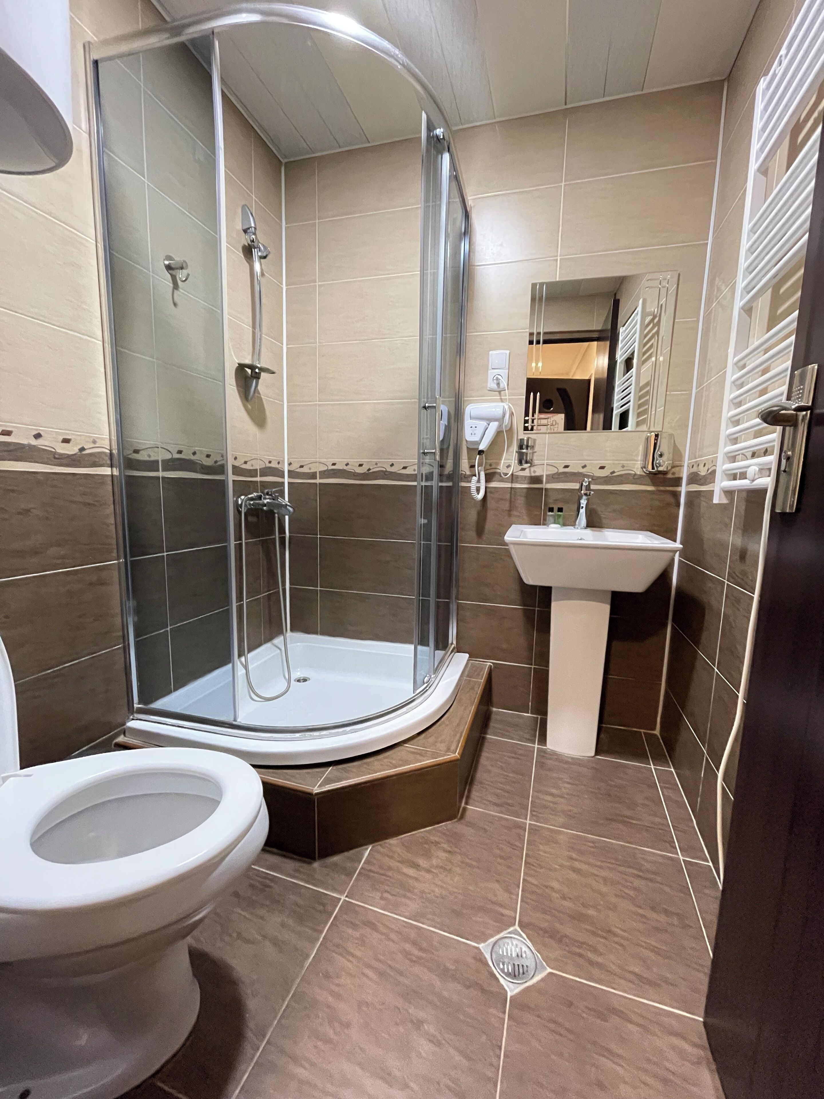 Un baño con ducha de mampara, inodoro y lavabo.