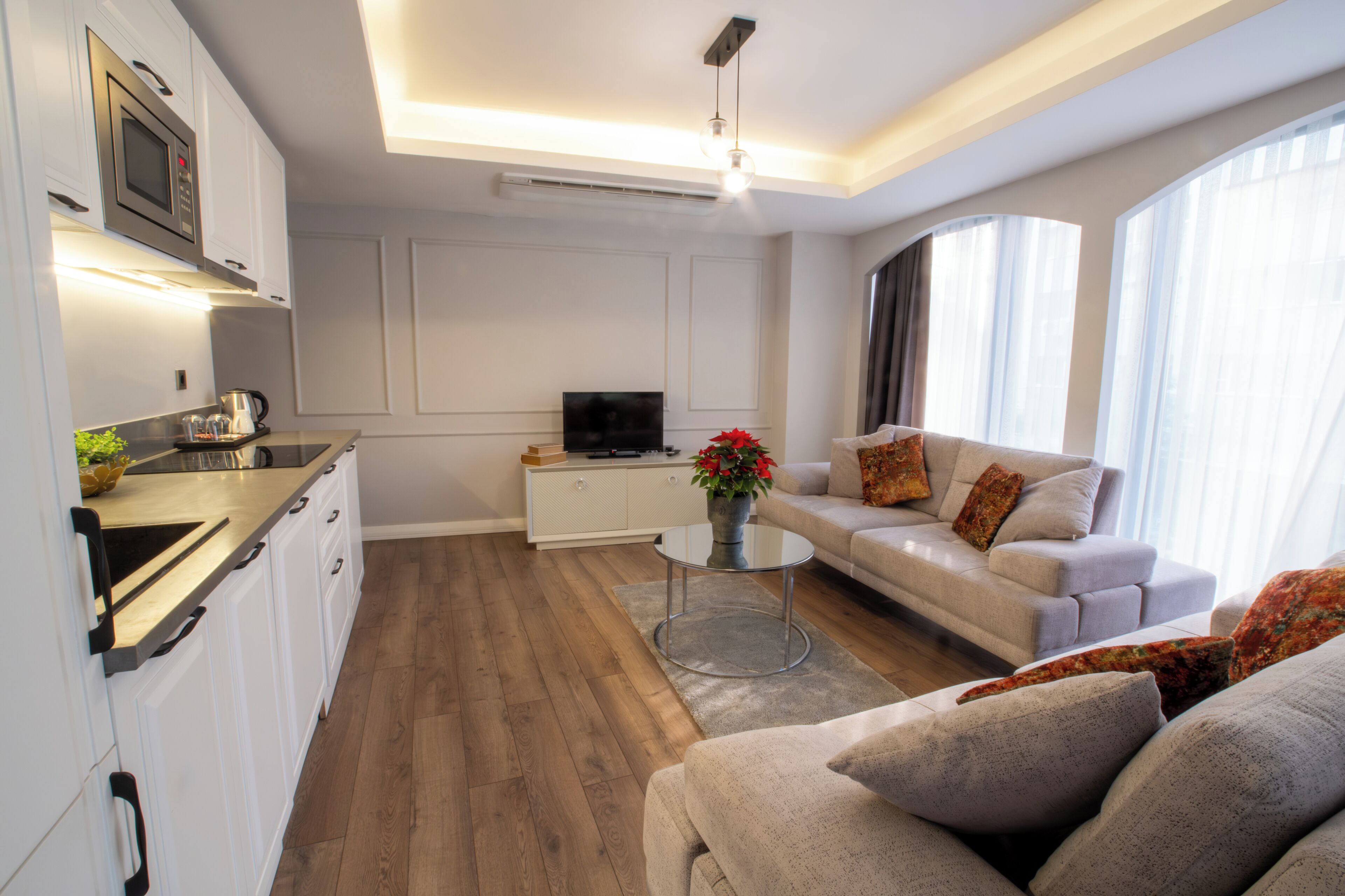 A modern living room with a sofa, coffee table, and a flat-screen TV.