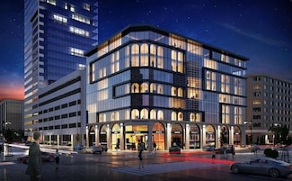 A modern hotel with a curved facade, multiple floors, and large windows.