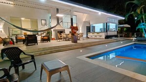 A pool area with lounge chairs, a hammock, and a bar area with outdoor seating. - Hermosa Casa Campestre a 1 Hora de Bogotá - Tena (TENA)