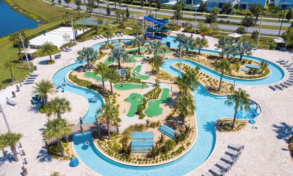A resort with a large swimming pool, water slides, and a basketball court.