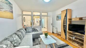 Comfort appartement, uitzicht op park | Woonruimte | Een 32-inch lcd-televisie met kabelzenders