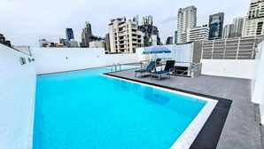 Ein Pool auf dem Dach mit einer Skyline im Hintergrund.