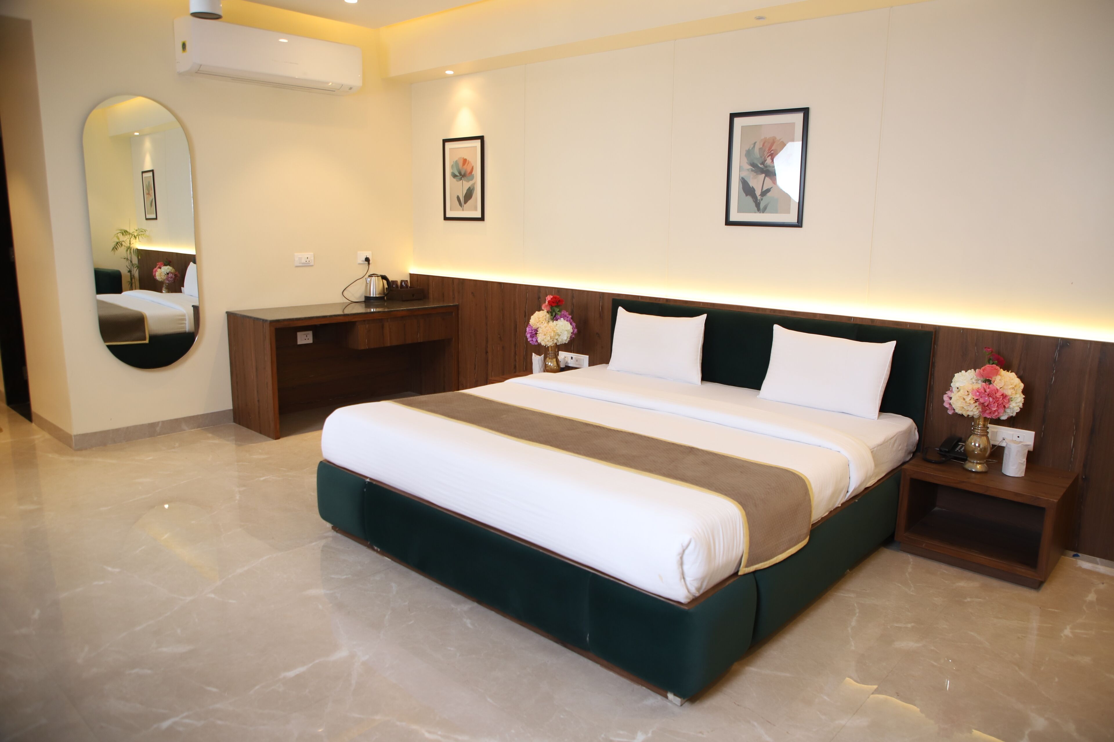 Una habitación de hotel moderna con una cama grande, un escritorio y un espejo.