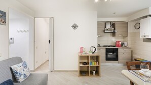 A modern apartment with a living room, a kitchen, and a dining area. - Comfy Apartment Near the Harbor by Wonderful Italy (Genoa)