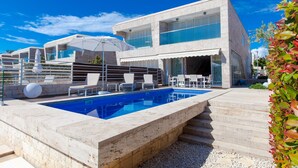 A modern two-story building with a swimming pool, outdoor seating, and a covered patio area. - Villa Calla Zadarvillas (Zadar)