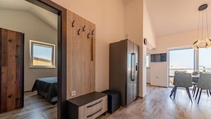 A modern kitchen with a built-in refrigerator, wooden wall paneling, and a dining area with a view. - Beautiful apartment in Prizna with WiFi (Prizna)
