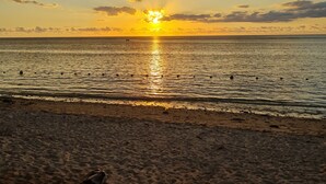A beach with a sunset over the ocean. - Le Mirage Cozy Beach Apartment, 5 min walk to the beach. Enjoy sunset view (Flic en Flac)