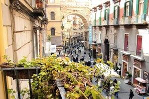 A narrow street with buildings on both sides, a pedestrian walkway, and a small cart. - Suite d'élite Chiaia (Naples)