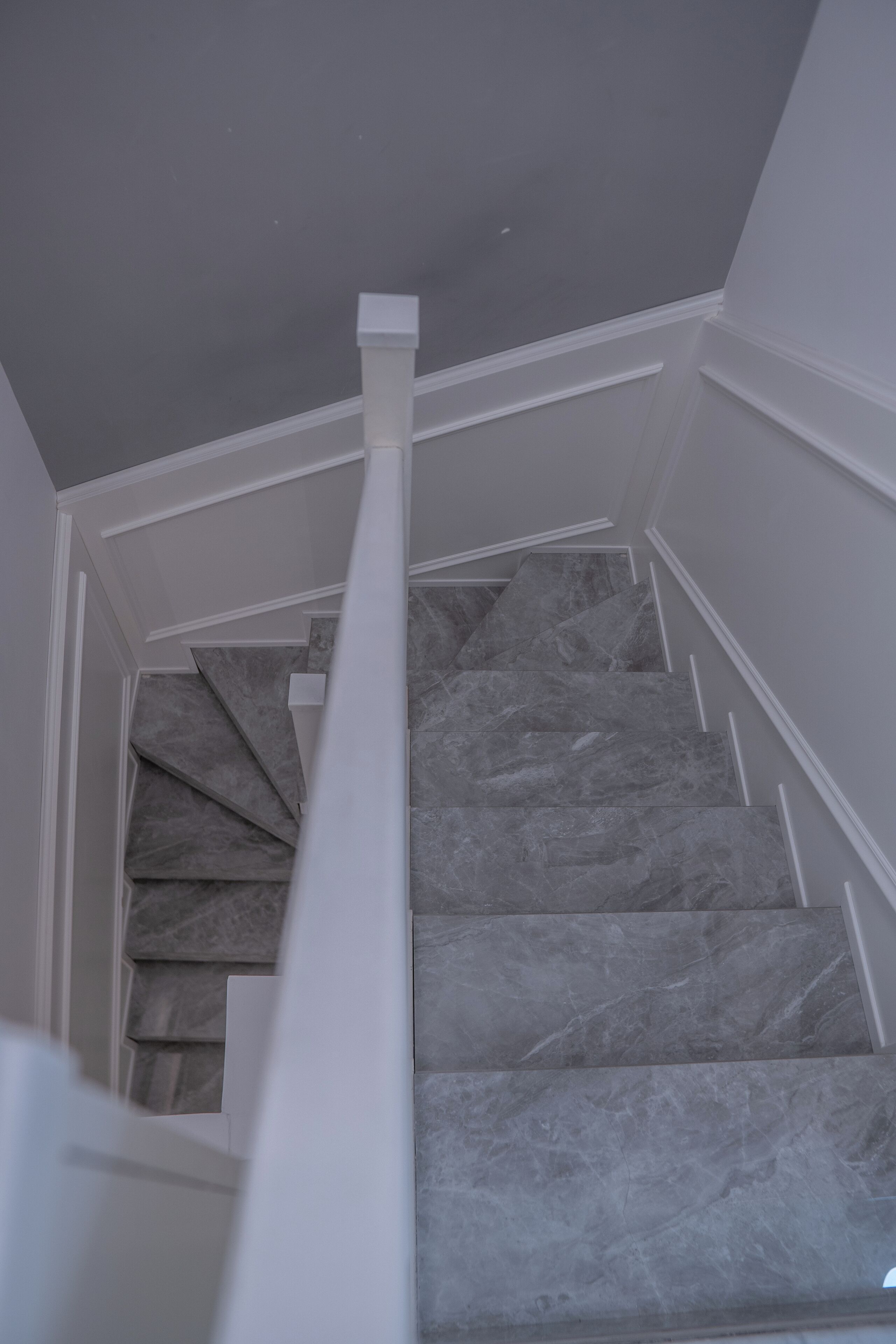 A staircase with marble steps and white handrails.