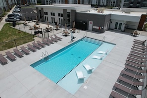 A rooftop pool with sun loungers and a covered seating area. - Landing | Amazing 2BD, Clubhouse, Pool (Indianapolis)