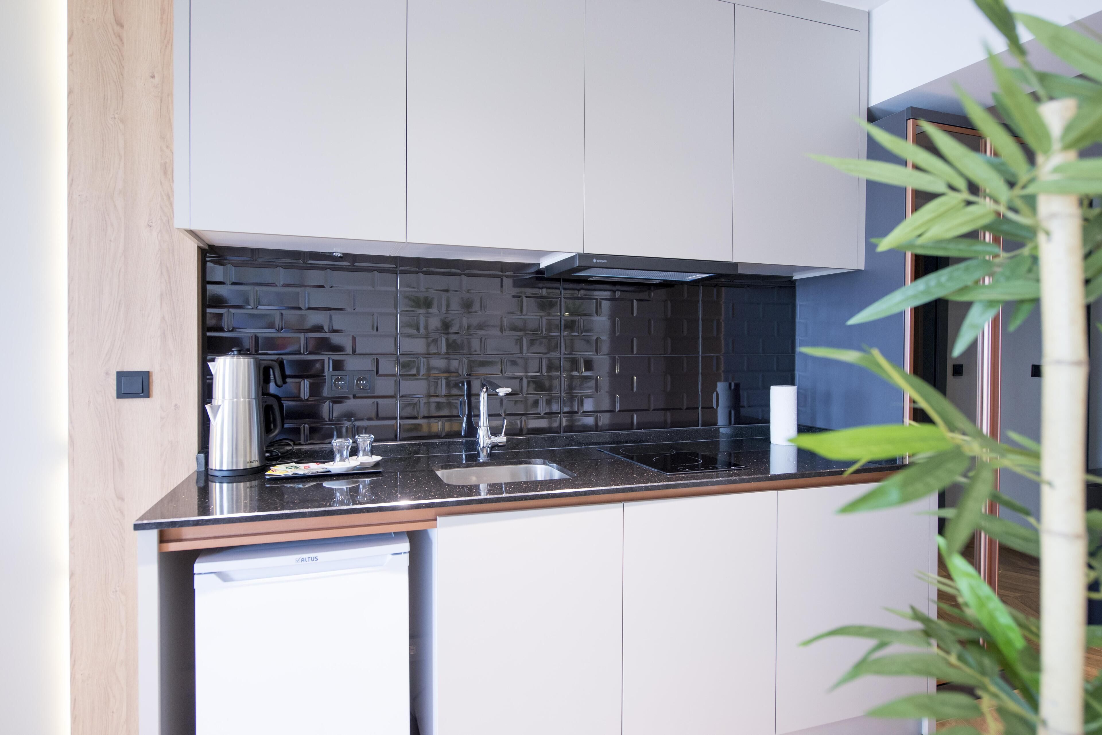 A modern kitchen with a black countertop, stainless steel appliances, and a dishwasher.