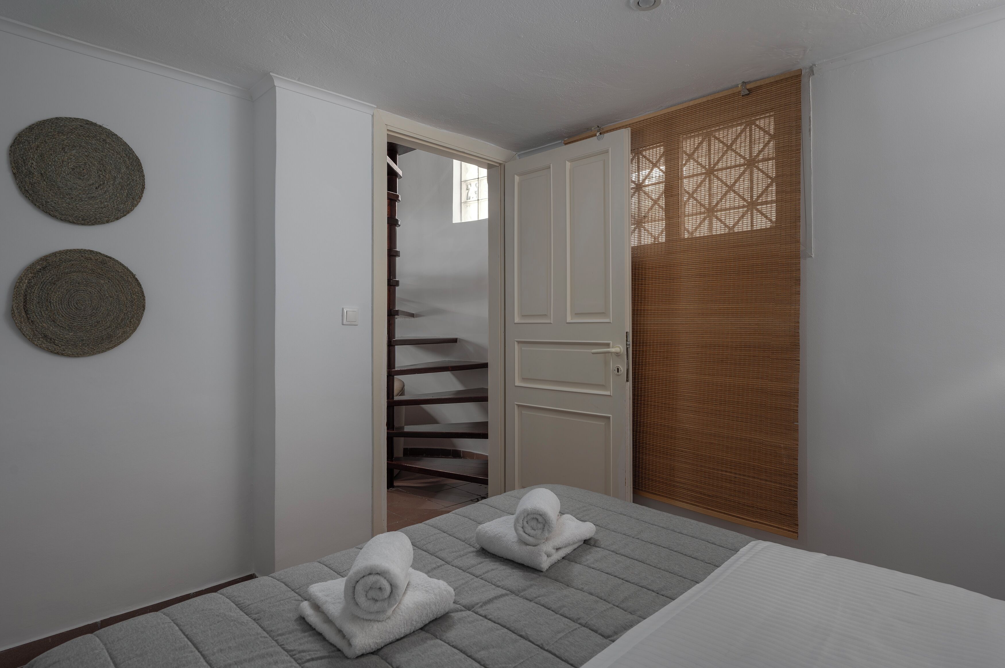 Une chambre à coucher avec un lit, deux serviettes, un placard et un escalier.