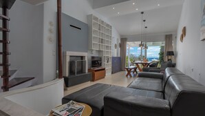Een moderne woonkamer met een bank, televisie en een trap.