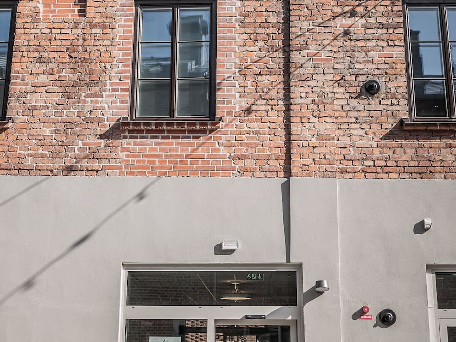 Een gebouw met een bakstenen gevel en een glazen ingang.