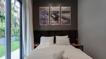 A hotel room with a large bed, two bedside tables, and a window with curtains.