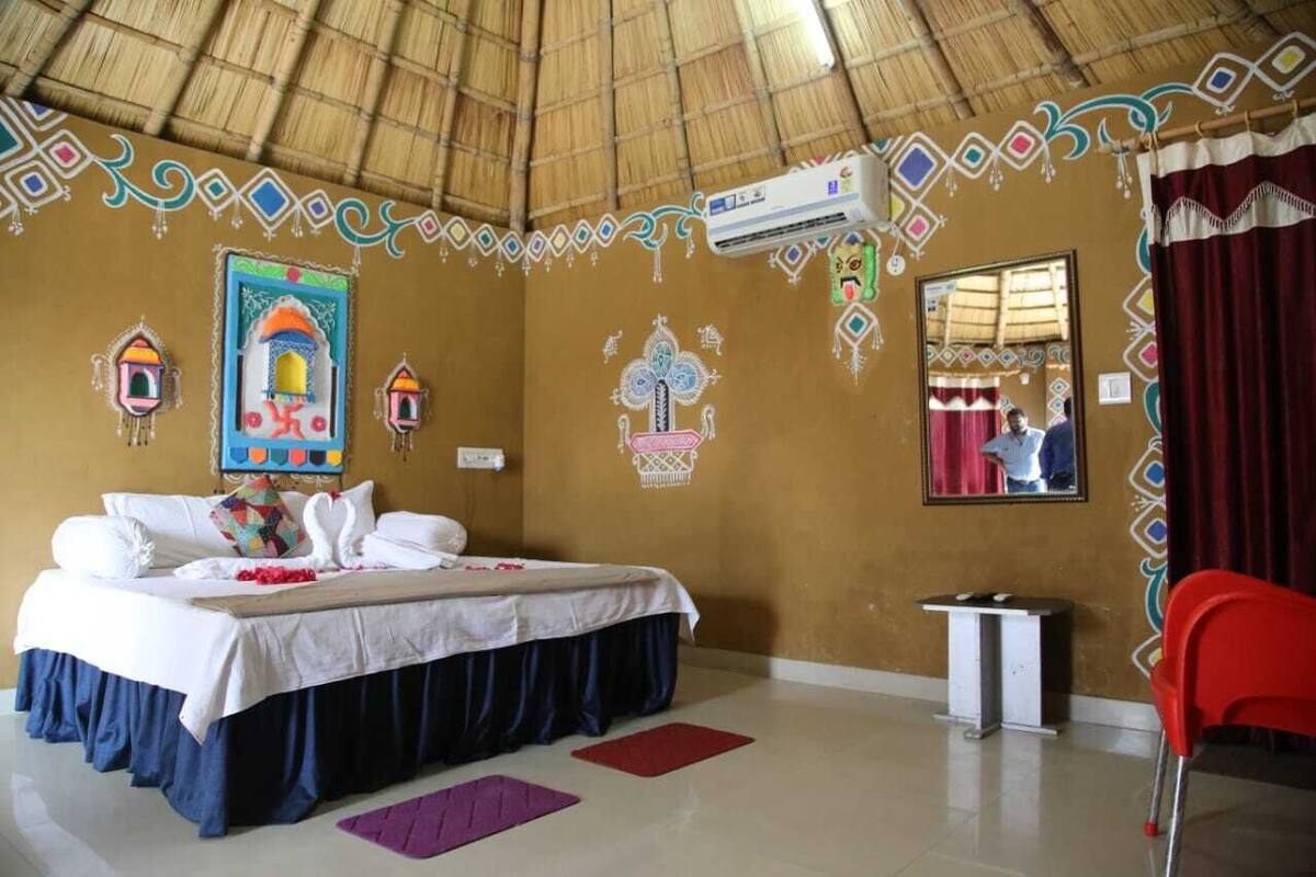 Una habitación con cama, una mesita, un espejo y decoración en las paredes.