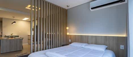A modern bedroom with a bed, an air conditioning unit, and a wooden partition.