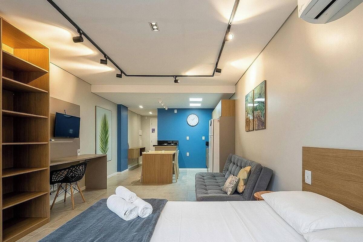 Une chambre d’hôtel moderne équipée d’un lit, d’un coin salon, d’un bureau et d’une télévision.