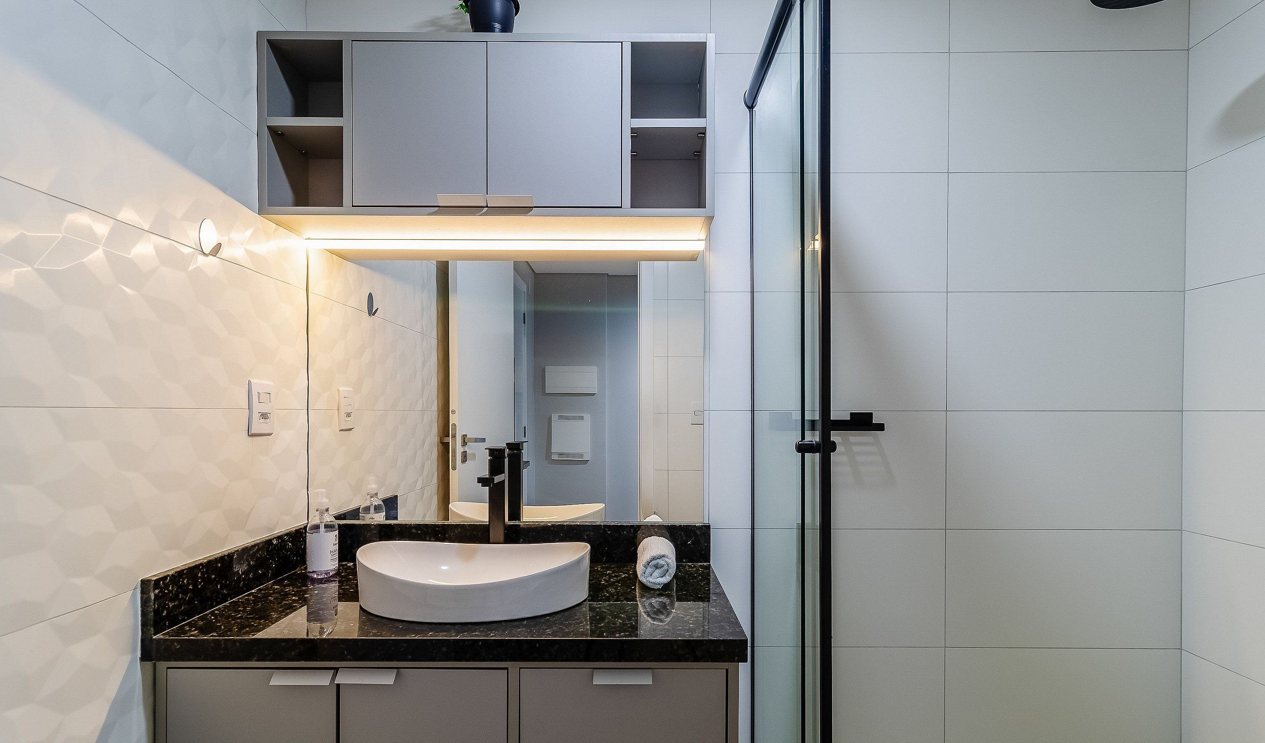A modern bathroom with a vanity, sink, and mirror.