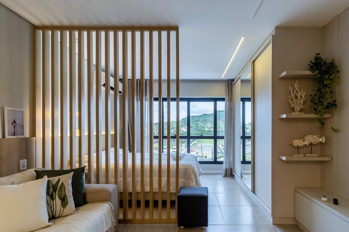 Une chambre d’hôtel moderne équipée d’un lit, d’un canapé, d’une télévision et offrant une vue sur l’extérieur.