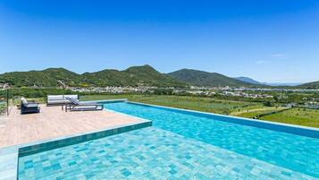 A swimming pool with a view of mountains and a distant town.