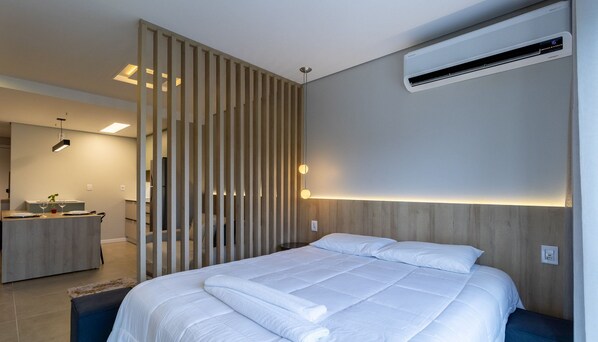 A modern bedroom with a bed, bedside table, and an air conditioning unit. - OKA Floripa (Florianópolis)