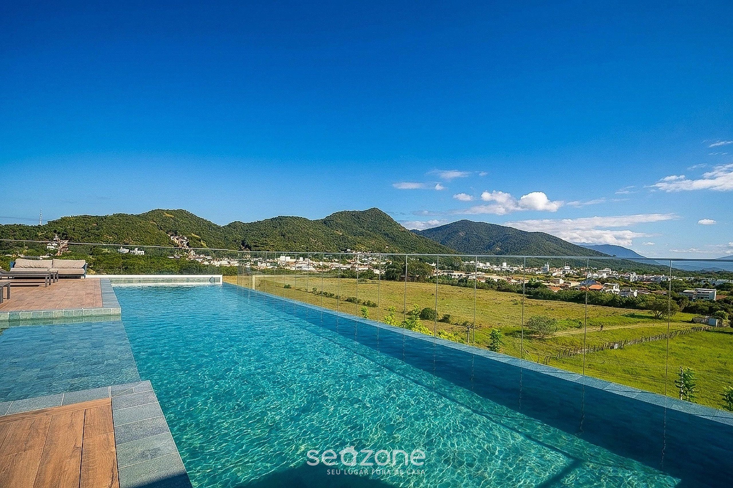 A swimming pool with a view of a town and mountains.