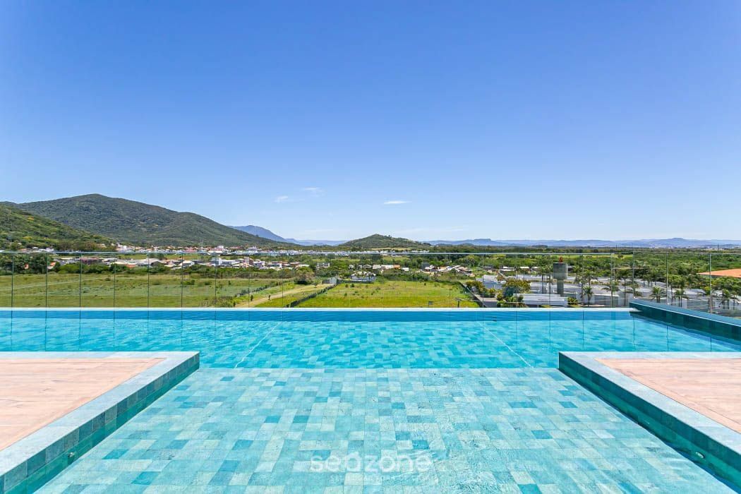 A swimming pool with a view of a green landscape and distant hills.