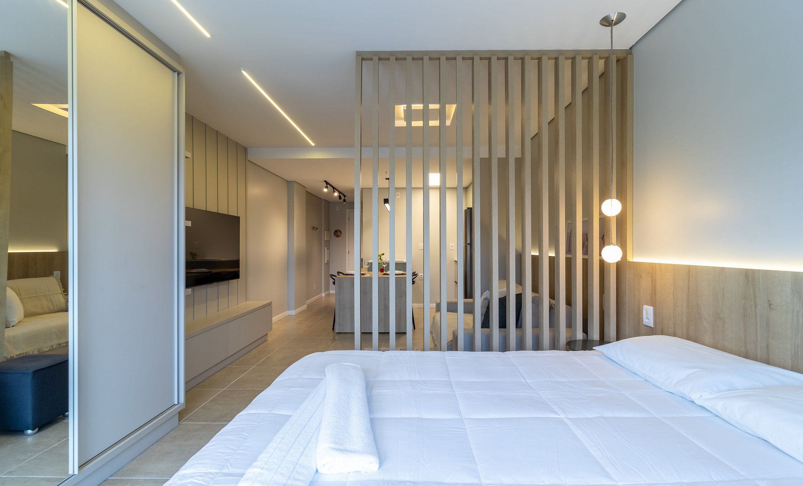 Une chambre d’hôtel moderne équipée d’un lit, d’un bureau et d’une télévision.