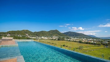 Una piscina con vista su una città e montagne.