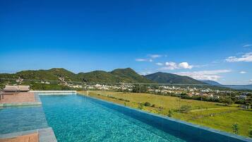 A swimming pool with a view of a town and mountains.