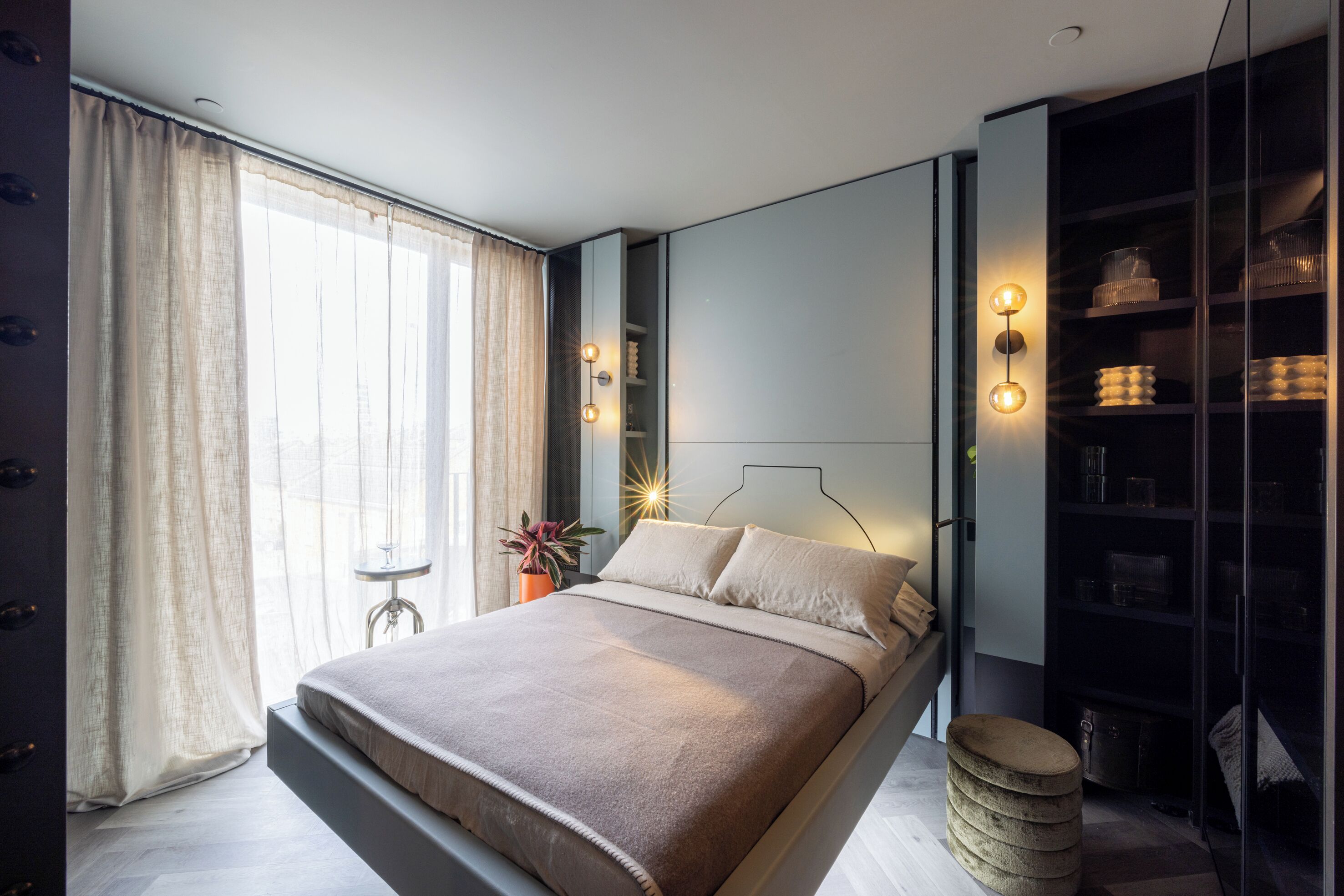 Ein modernes Schlafzimmer mit Bett, Nachttisch und integriertem Kleiderschrank.