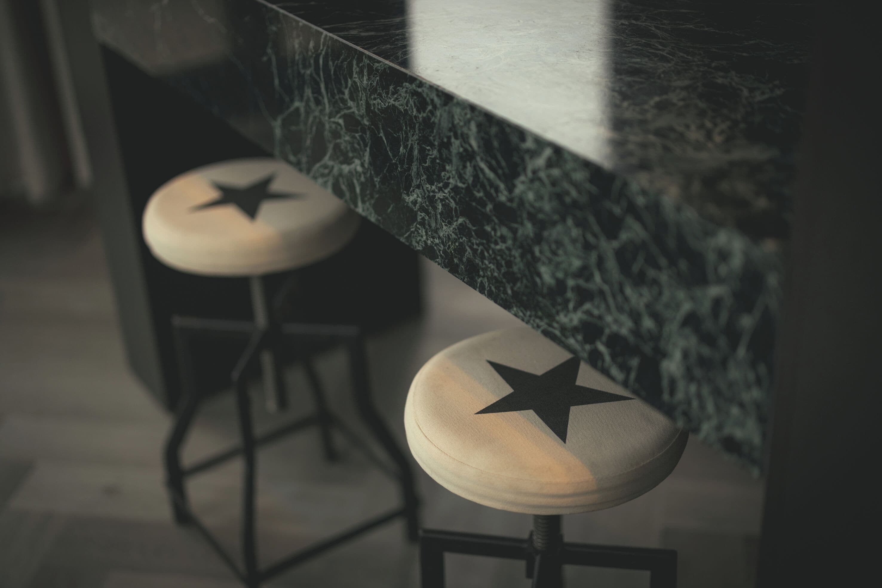 A bar area with two stools, each featuring a star design on the seat.