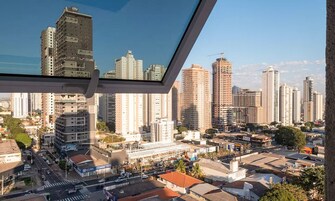 Un paisaje urbano con rascacielos, cielo despejado y vista a través de una ventana.