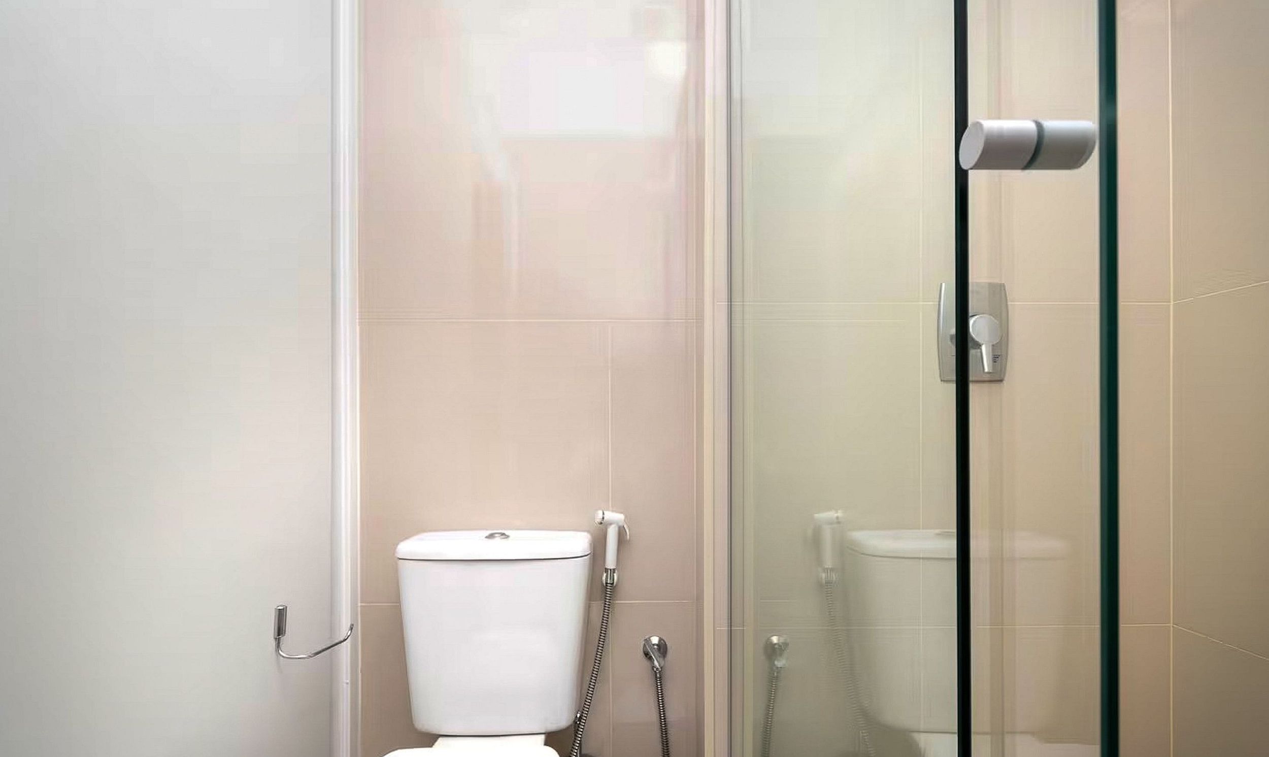 Un bany modern amb una cabina de dutxa de vidre, un vàter i un bidé.