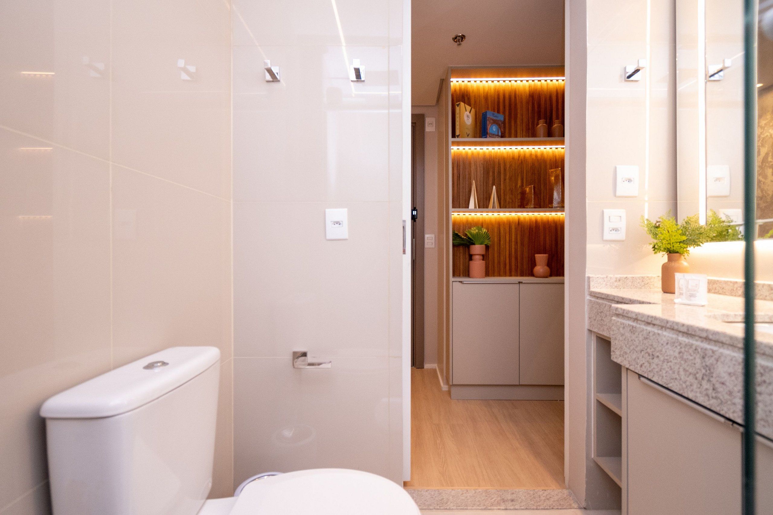 Une salle de bain moderne équipée de toilettes, d’une douche et d’un meuble-lavabo avec un miroir.