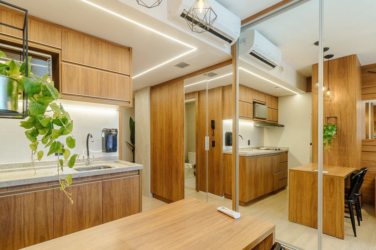 Une cuisine moderne avec des meubles en bois, une cuisinière encastrée et une machine à café.