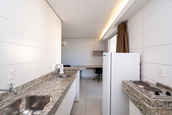 Een moderne keuken met granieten werkbladen, een roestvrijstalen spoelbak en een ingebouwde kookplaat.