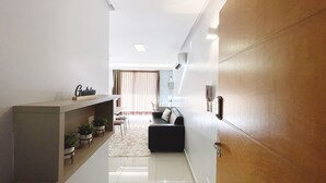 Un intérieur moderne comprenant un canapé, un coin repas et une cuisine.