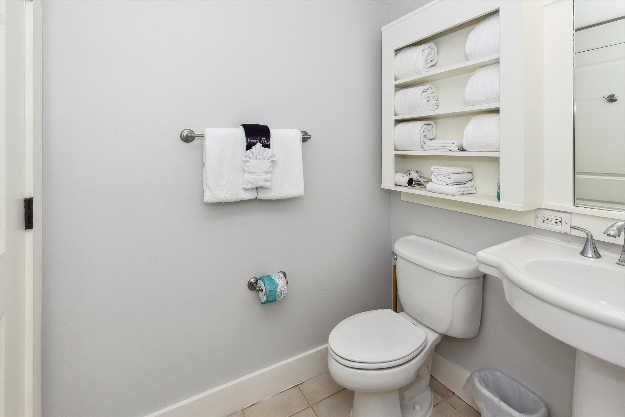 Un baño con inodoro, lavamanos y toallero.
