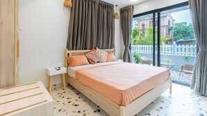 Un dormitorio con cama, mesita de noche y vistas al exterior.